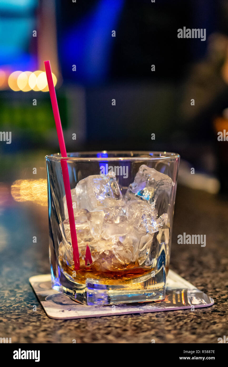 Svuotare bevanda miscelata bicchiere da cocktail con paglia sulla barra Coaster sul Bar Sala Superiore per la copia Foto Stock