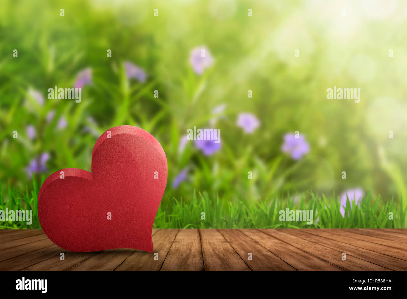 Cuore rosso disteso sul pavimento in legno Foto Stock