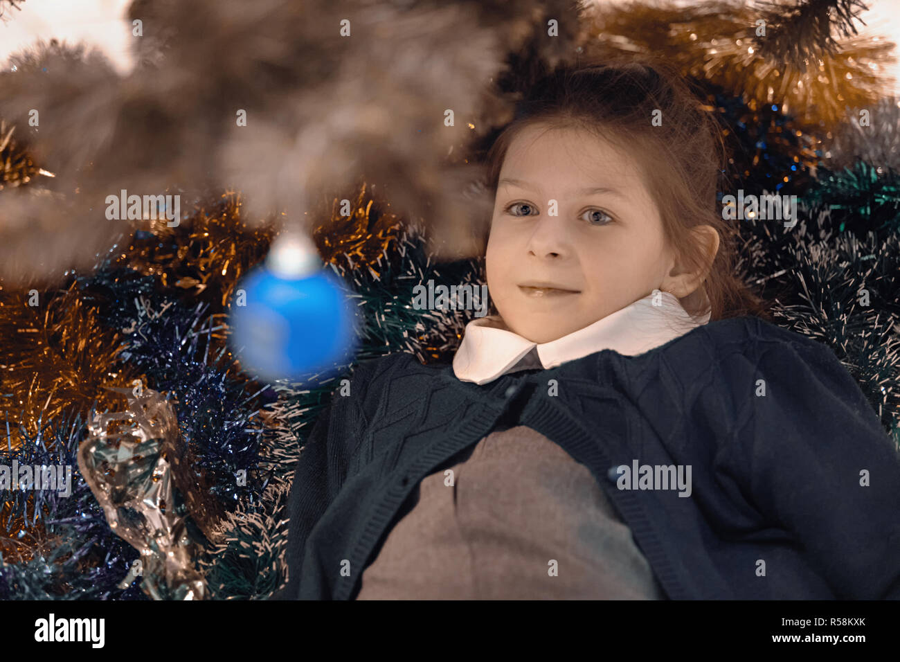 Ragazza adolescente presso l albero di Natale giocattoli sulla struttura ad albero si sta preparando per il nuovo anno e di Natale Foto Stock