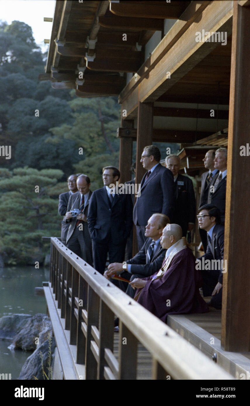 1974, Novembre 21 - Kinkakuji Castello (Padiglione d'Oro) - Kyoto, Giappone - Gerald Ford, buddisti Zen Abate Jikai Murakami, interprete, il Segretario di Stato Henry Kissinger A., Donald Rumsfeld; altri membri di USA e giapponesi viaggiano in gruppo - un interprete siede tra il Presidente Ford e buddisti Zen Abate Jikai Murakami come le due sessioni di chat in il padiglione sopra il Cyoko Chi Pond - Prima visita in Giappone da una seduta il Presidente USA - Tour di Zen santuario buddista - Abbott del Padiglione d'Oro Foto Stock