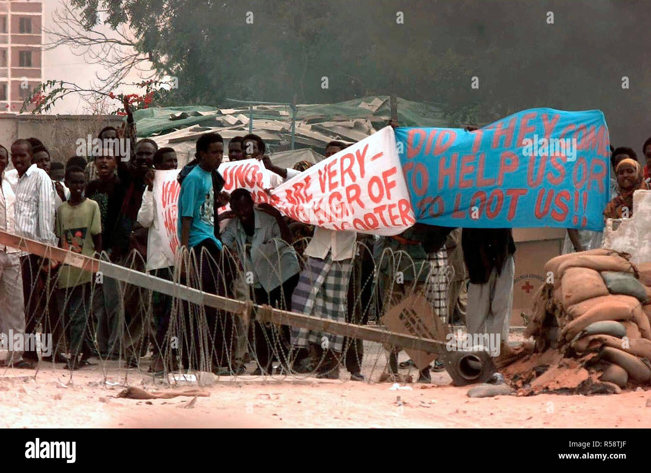 1993 - popolo somalo tenere premuto su un banner in segno di protesta al cancello 8 dell'ambasciata Usa a Mogadiscio. Essi sembrano essere la protesta della esistenza di le forze della coalizione hanno assegnato a Restore Hope. Foto Stock
