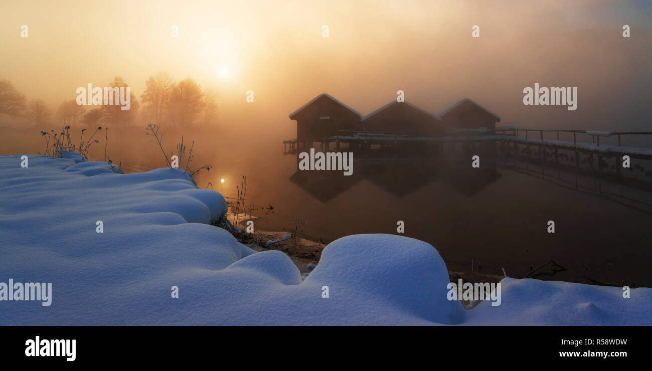 Sunrise in inverno sulle capanne pescatore al lago, Kochelsee, dello Stato libero di Baviera, Germania Foto Stock