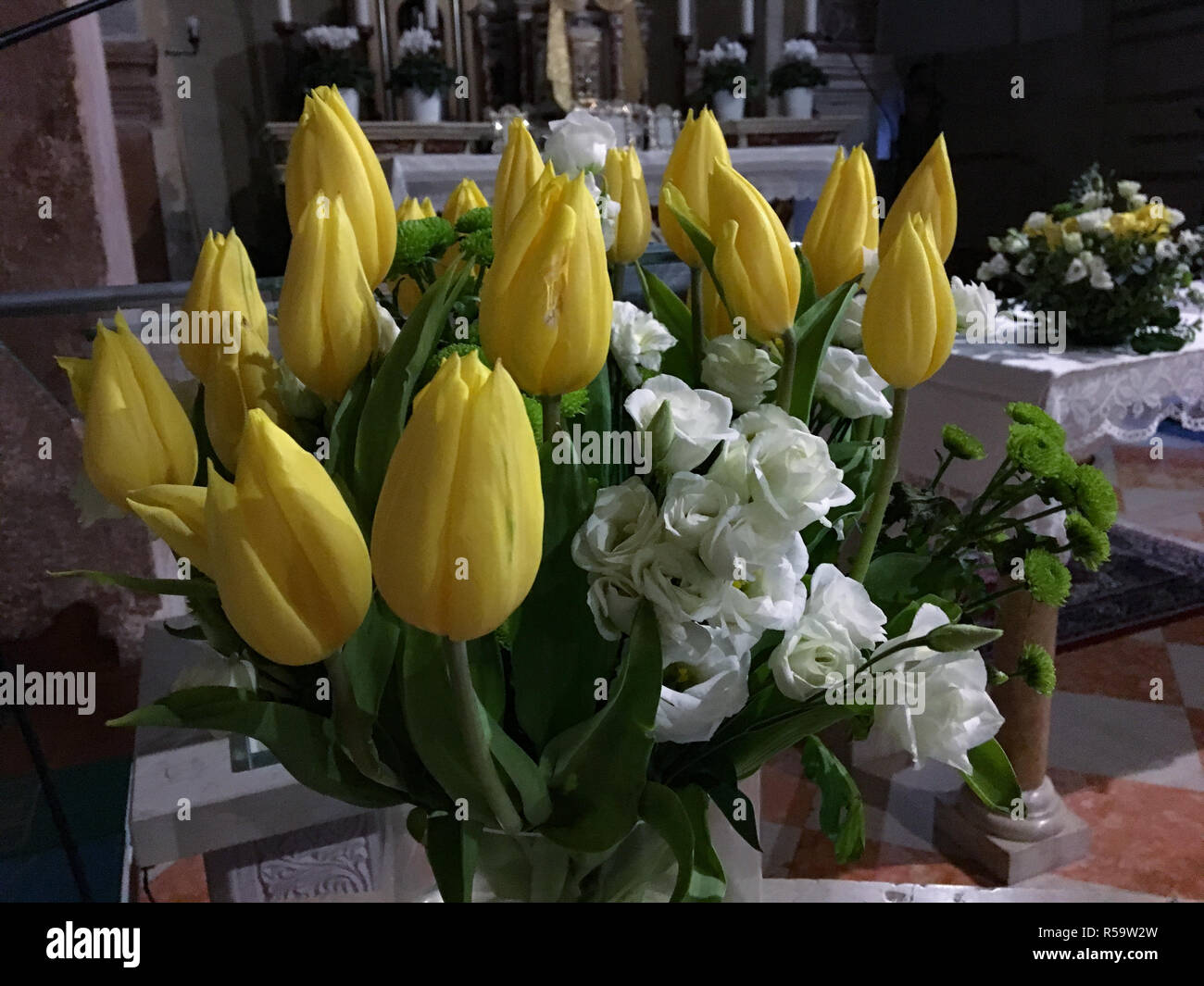 Mazzo di fiori di tulipani gialli e rose bianche. Bouquet sull'altare nella  chiesa. Decorazioni floreali per eventi e matrimoni Foto stock - Alamy