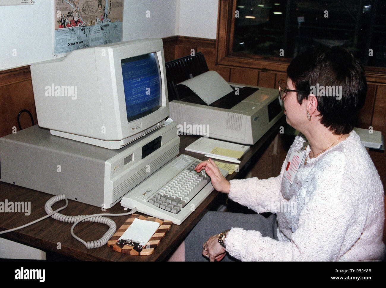 Un dipendente utilizza un personal computer per monitorare i record presso il comune di informazioni visive Agenzia. Foto Stock