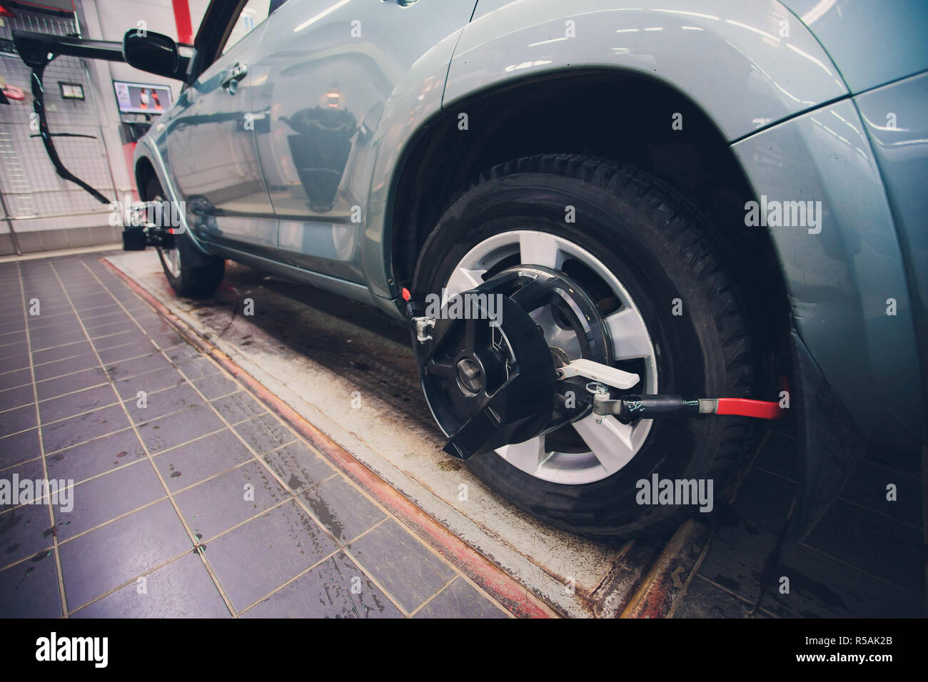 Meccanico allineatore di tuning per allineamento ruote in garage closeup.  Auto professionali di manutenzione in officina moderna Foto stock - Alamy