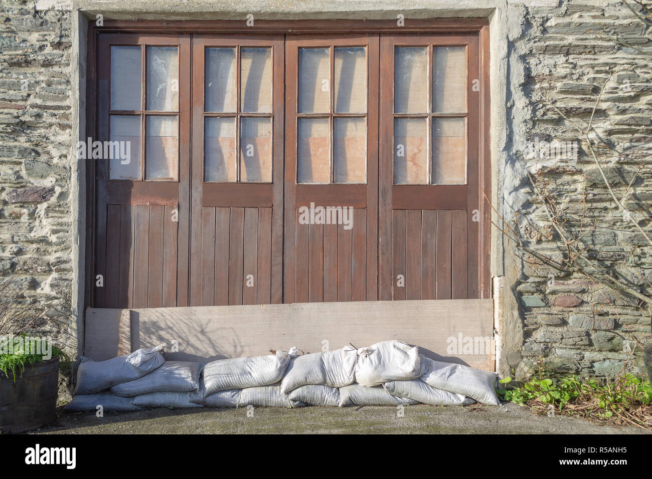 Sacchi di sabbia e di tavole di legno inchiodati in un portale come le misure di difesa contro le inondazioni o flood barrier Foto Stock