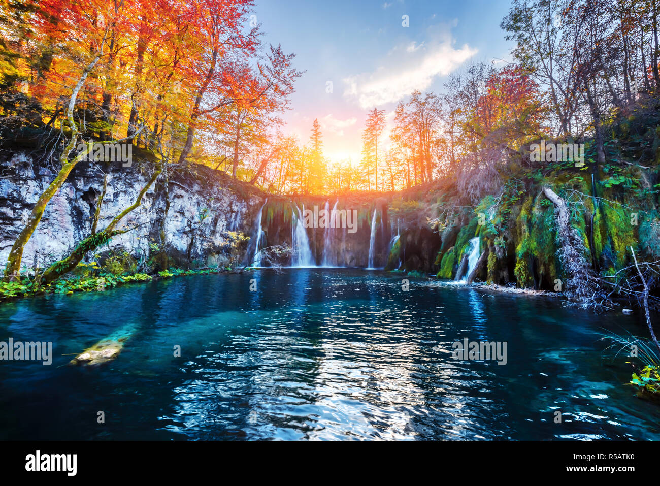 Incredibile cascata con pura acqua blu nel Parco Nazionale dei laghi di Plitvice. Orange autunno foresta sul background. Il parco nazionale di Plitvice, Croazia. Fotografia di paesaggi Foto Stock