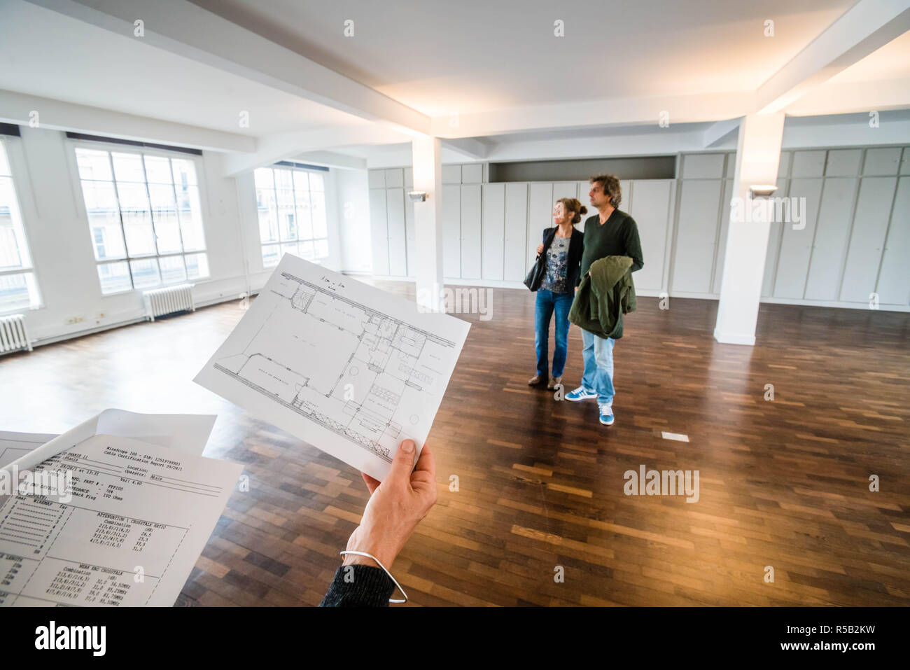 Giovane visitando un loft con un agente immobiliare. Foto Stock