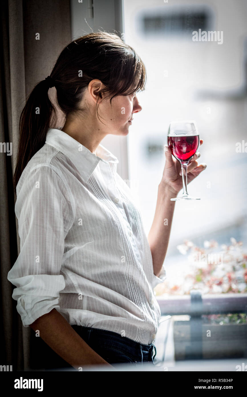 Donna di bere un bicchiere di vino rosso. Foto Stock