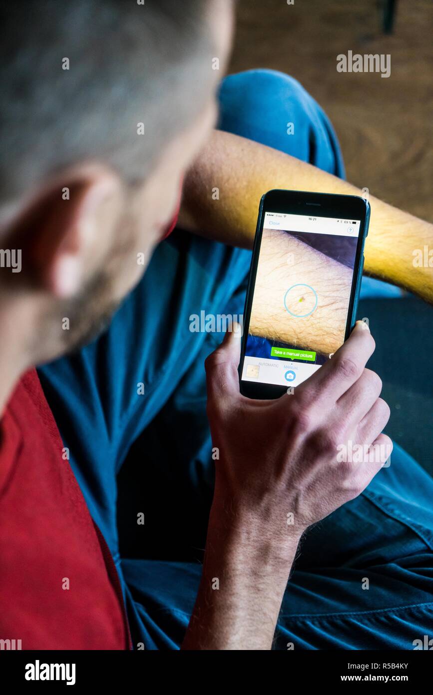 Uomo salute mediante applicazione sul suo Iphone®. Foto Stock