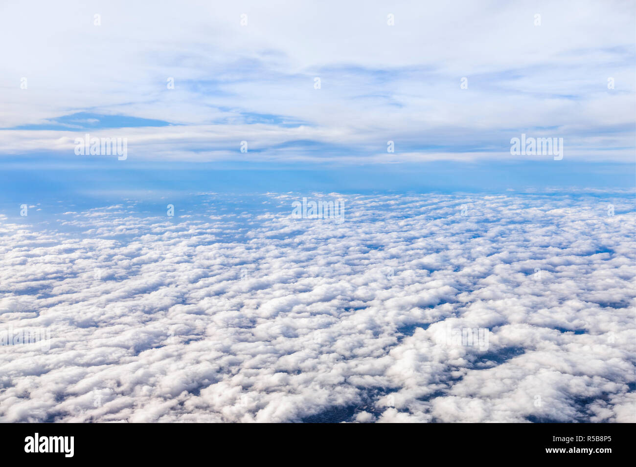 Nuvole al di sopra e al di sotto sono divisi da un orizzonte di cielo blu. Foto Stock