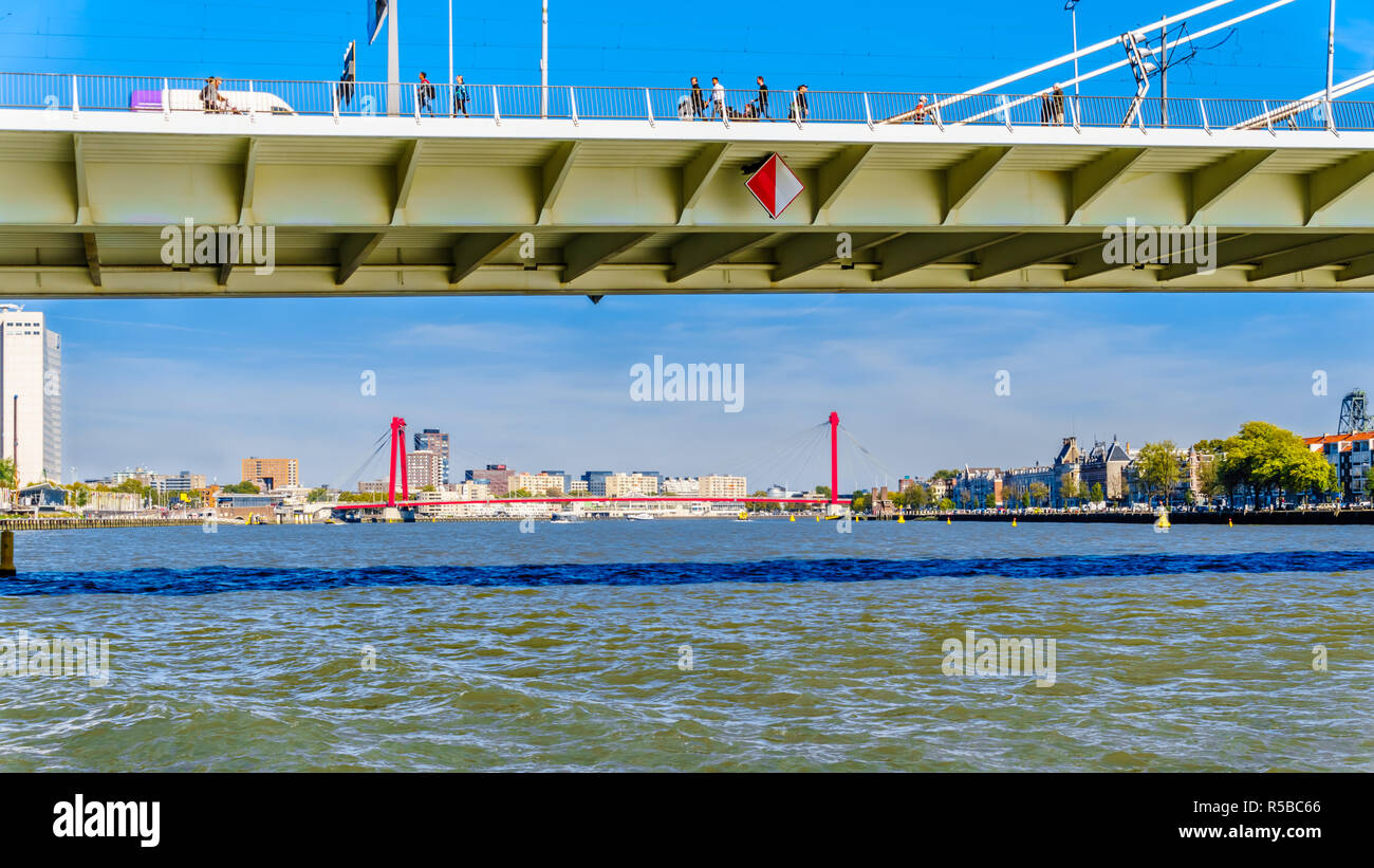 La Nieuwe Maas fiume con il cavo rosso alloggiato Willems ponte in background e le case storiche sulla riva di Noordereiland Foto Stock