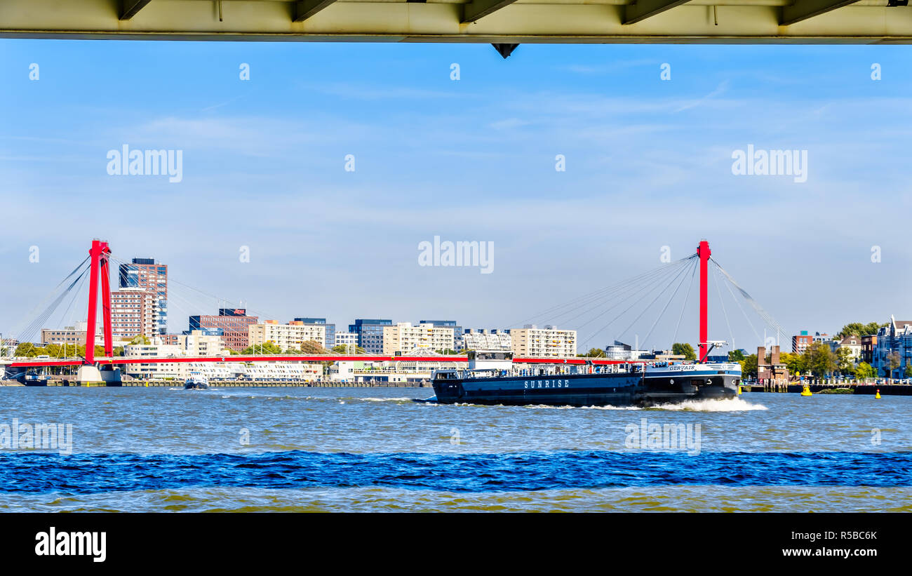 La Nieuwe Maas fiume con il cavo rosso alloggiato Willems ponte in background e le case storiche sulla riva di Noordereiland Foto Stock