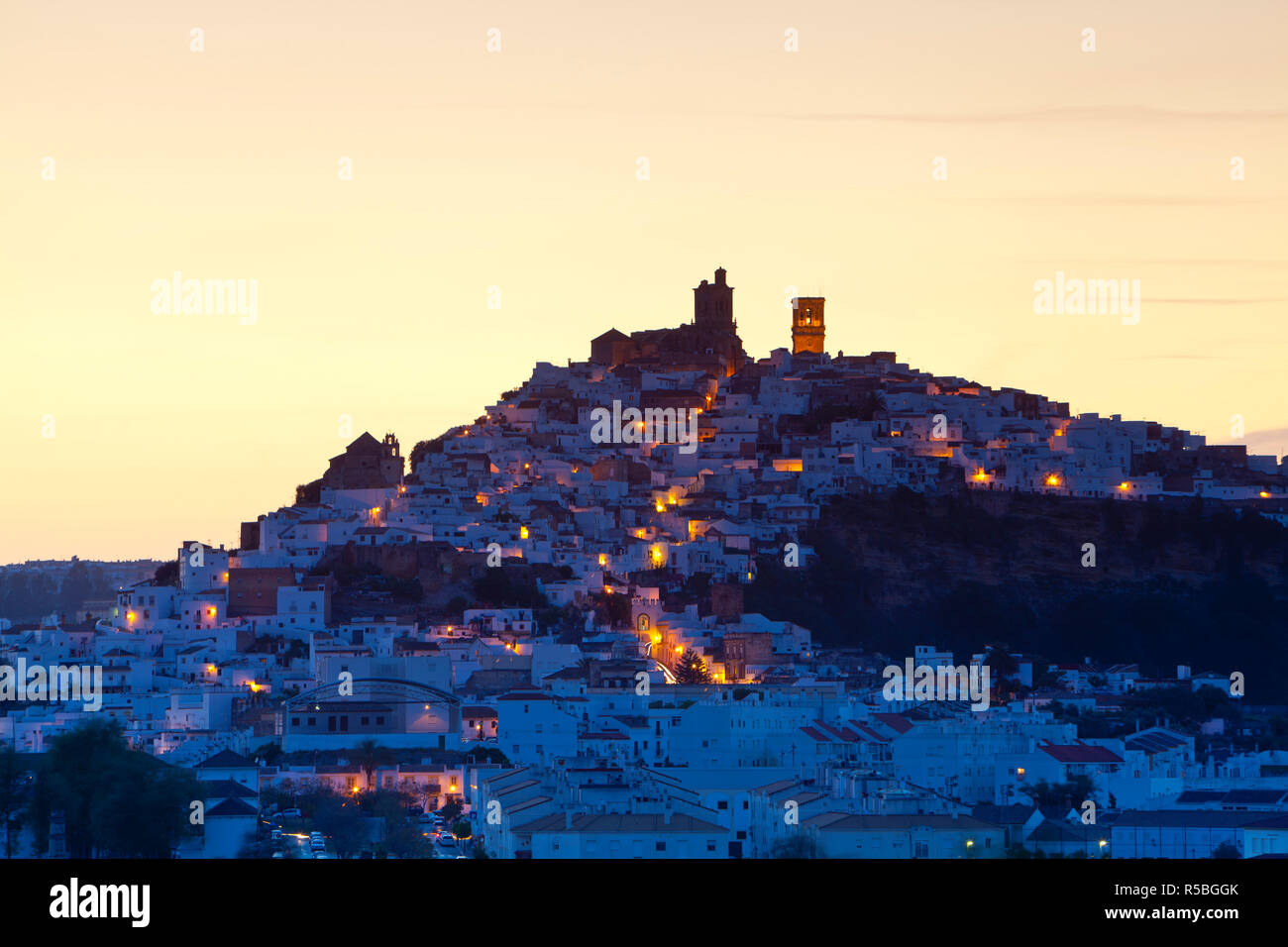 Chiesa campanili & case bianche illuminted al crepuscolo, Arcos de la Fontera, la provincia di Cadiz Cadice, Andalusia, Spagna Foto Stock