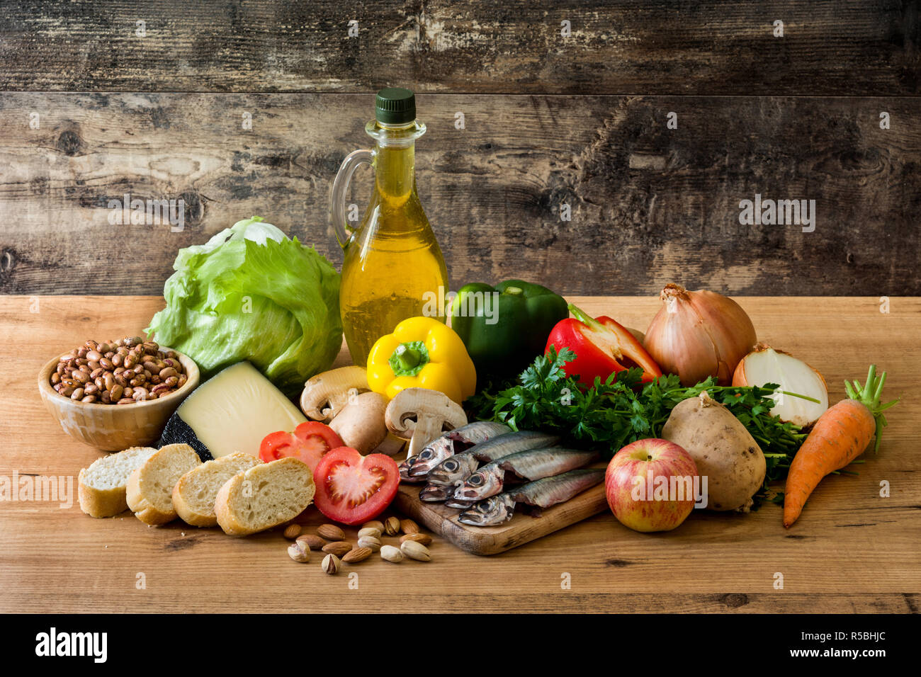 Mangiare sano. Dieta mediterranea. Frutta, verdura, cereali, noci olio d'oliva e di pesce sul tavolo di legno Foto Stock