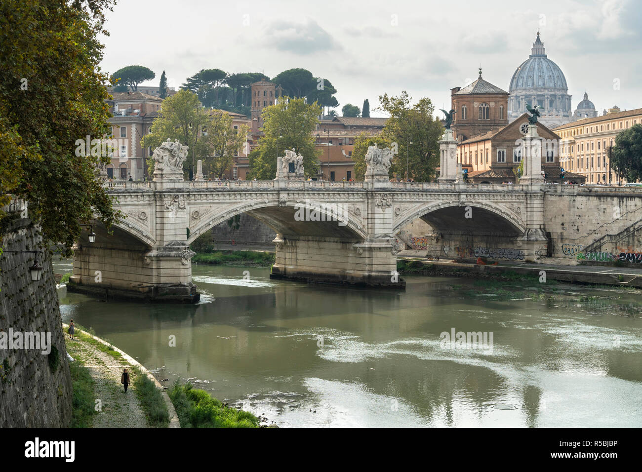 Il fiume Tevere e il Ponte Vittorio Emanuele II con la cupola della Basilica di San Pietro in lontananza, centrali di Roma, Italia. Foto Stock
