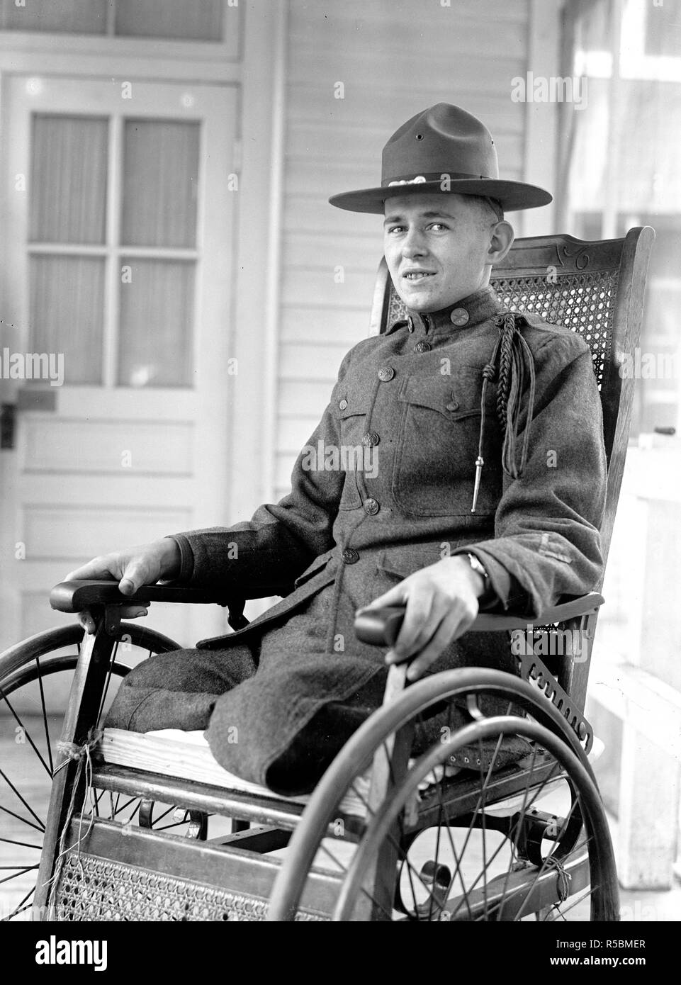 Soldato che ha perso le gambe nella I guerra mondiale nella sua sedia a rotelle ca. 1916-1919 Foto Stock