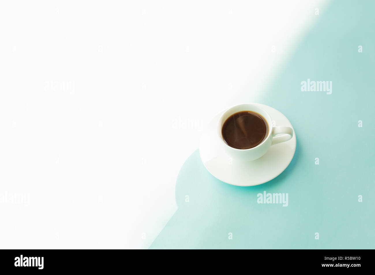 Tazza di caffè fumante sul blu turchese tabella. Foto astratte di caldo bere il caffè espresso su azzurro-verde dello sfondo. Foto Stock