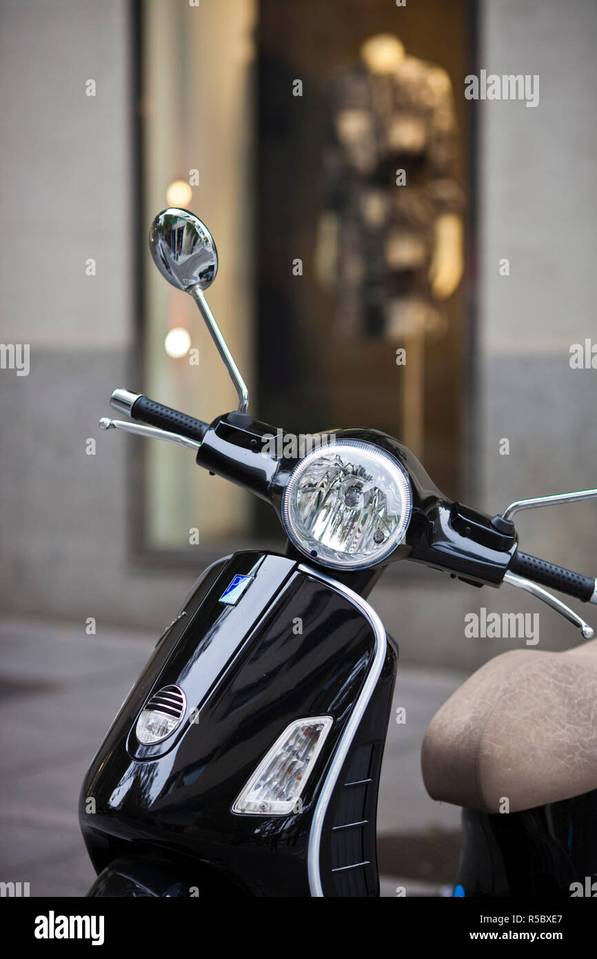 Spagna, Madrid, Area Salamanca, Calle de José Ortega y Gasset, Madrid è esclusiva via dello shopping, nero scooter Vespa Foto Stock