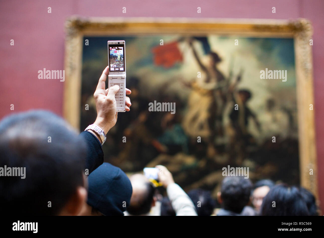 Francia, Parigi Musee du Louvre, francese del XIX secolo galleria di pittura, i visitatori di fotografare il dipinto la libertà di guidare il popolo Delacroix Foto Stock