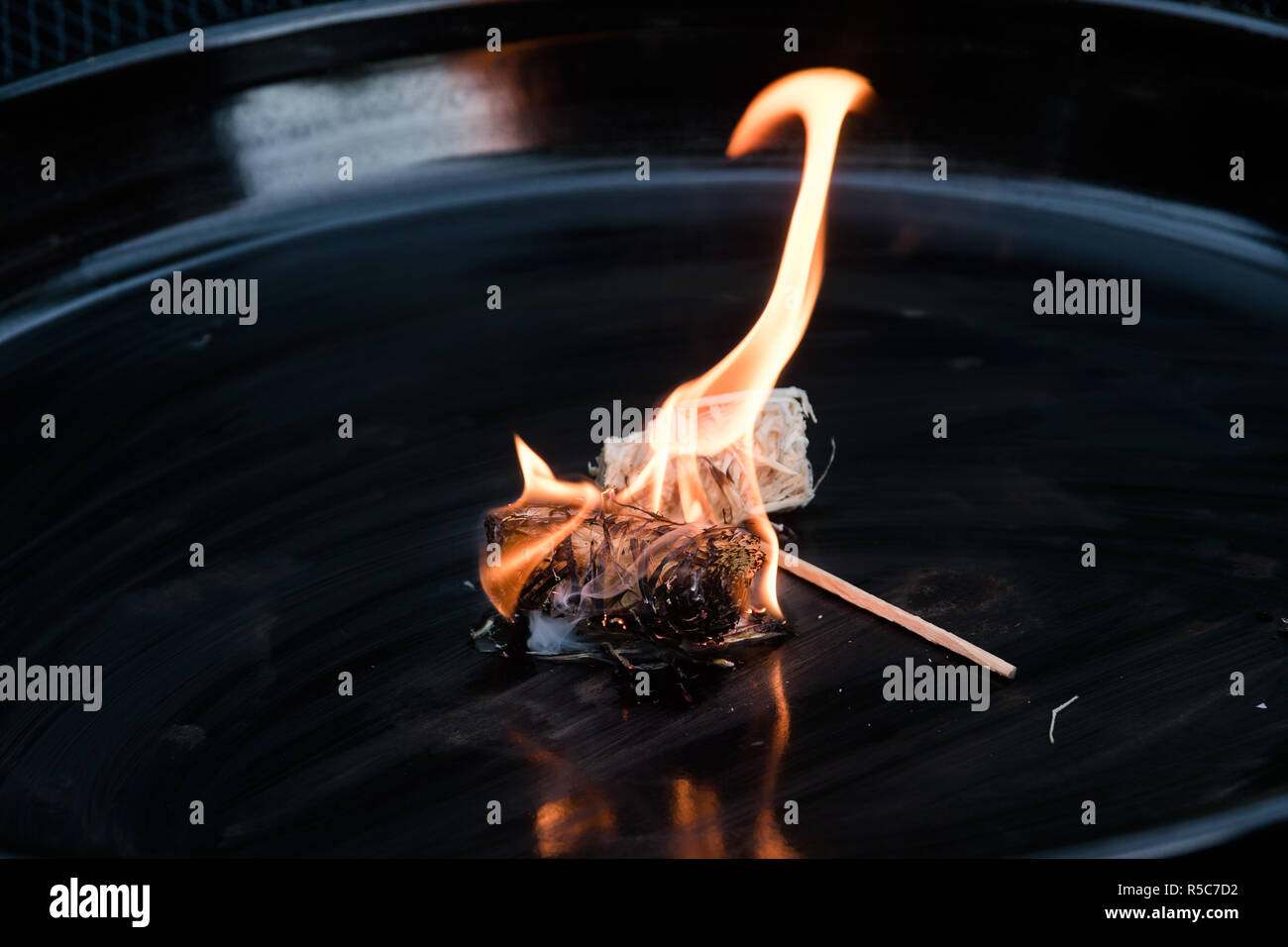 Masterizzazione di barbecue naturale accendino da lana di legno nero a piastra metallica, copia dello spazio, messa a fuoco selezionata Foto Stock