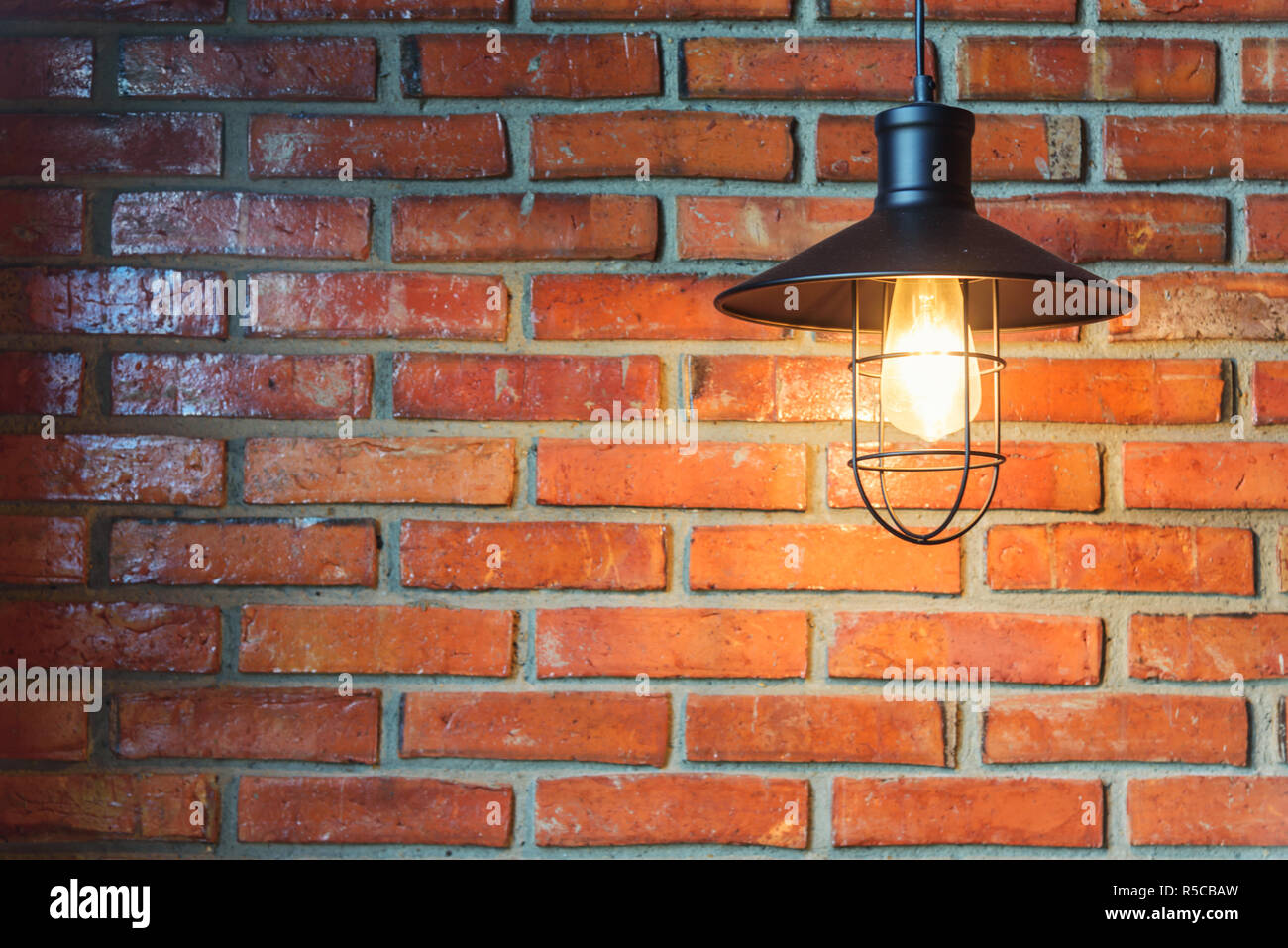 Vecchio tungsten lampadina su Sfondo mattone Foto Stock