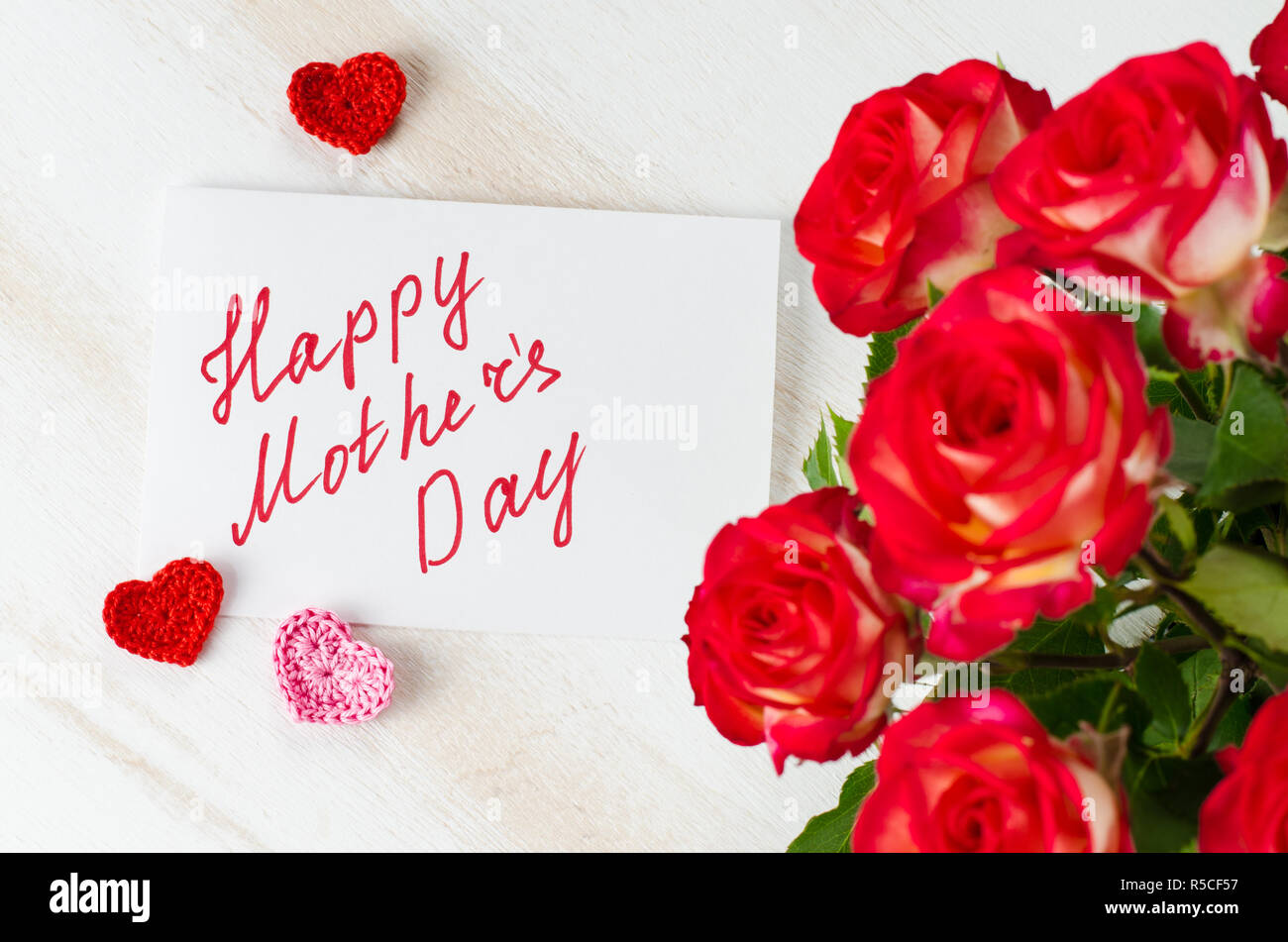 Bouquet di rose rosse e biglietto di auguri con il testo felice festa della  mamma Foto stock - Alamy