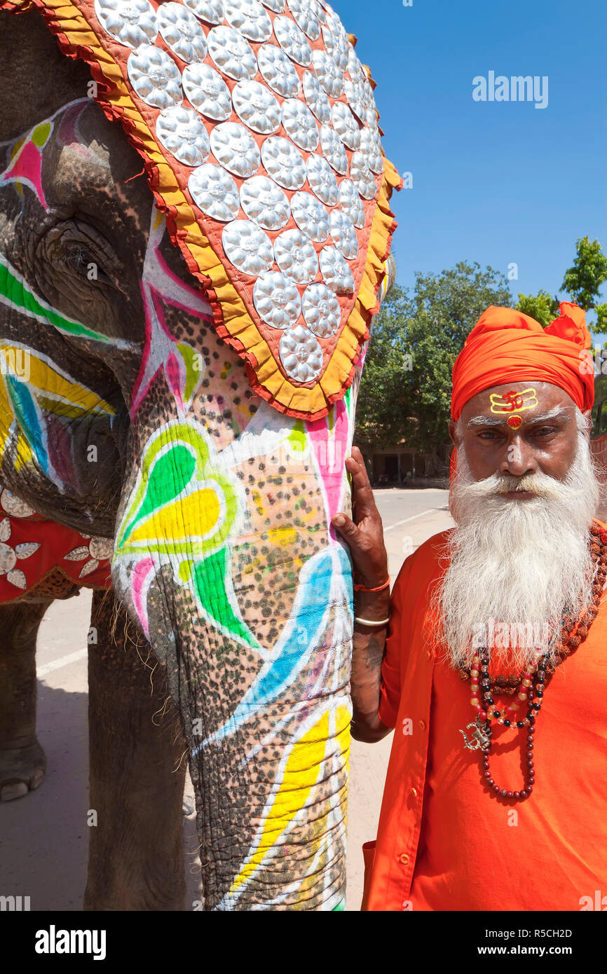India Rajasthan, Jaipur, decorate cerimoniale elefante e santo Saddhu in piedi al di fuori del palazzo di città, (MR) Foto Stock