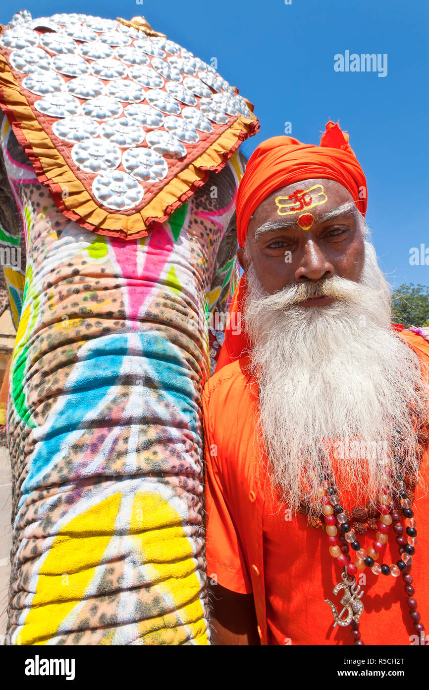 India Rajasthan, Jaipur, decorate cerimoniale elefante e santo Saddhu in piedi al di fuori del palazzo di città, (MR) Foto Stock
