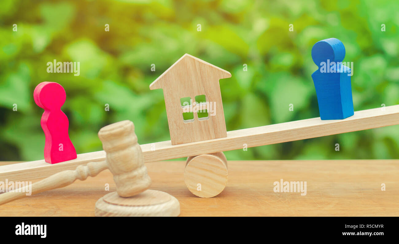 Divisione della proprietà mediante mezzi legali il chiarimento di proprietà della casa in legno per le figure di persone. l uomo e la donna sono in piedi sulle scale. tria Foto Stock