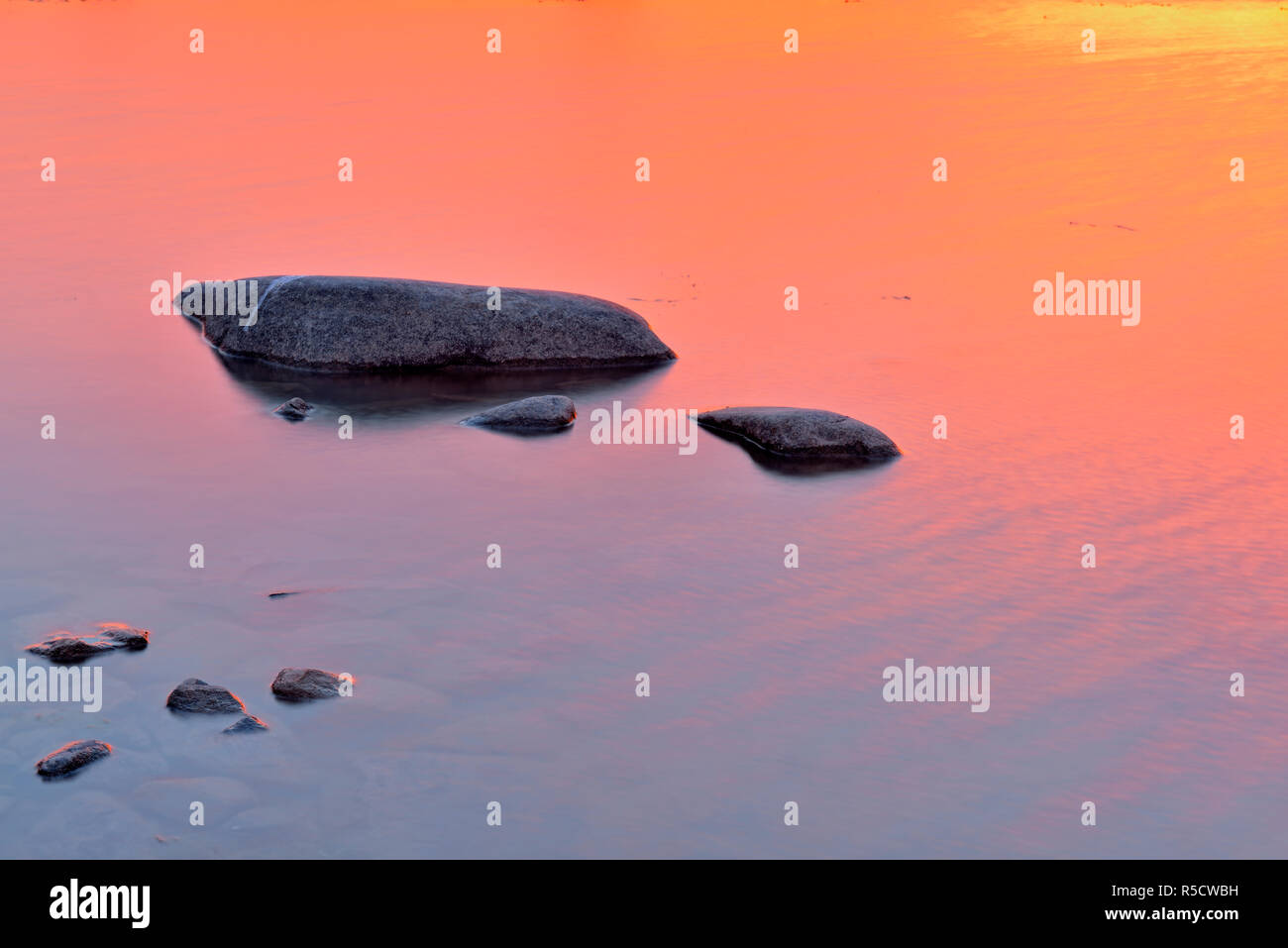 Sunrise skies riflessa nel fiume MacKenzie acque vicino a riva, Fort Providence, Northwest Territories, Canada Foto Stock