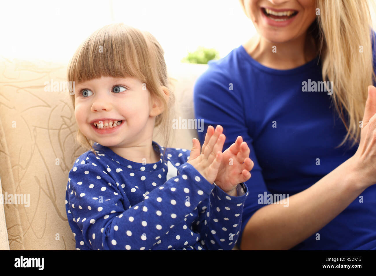 Carino bambina gioca con mom pat-un-torta Foto Stock