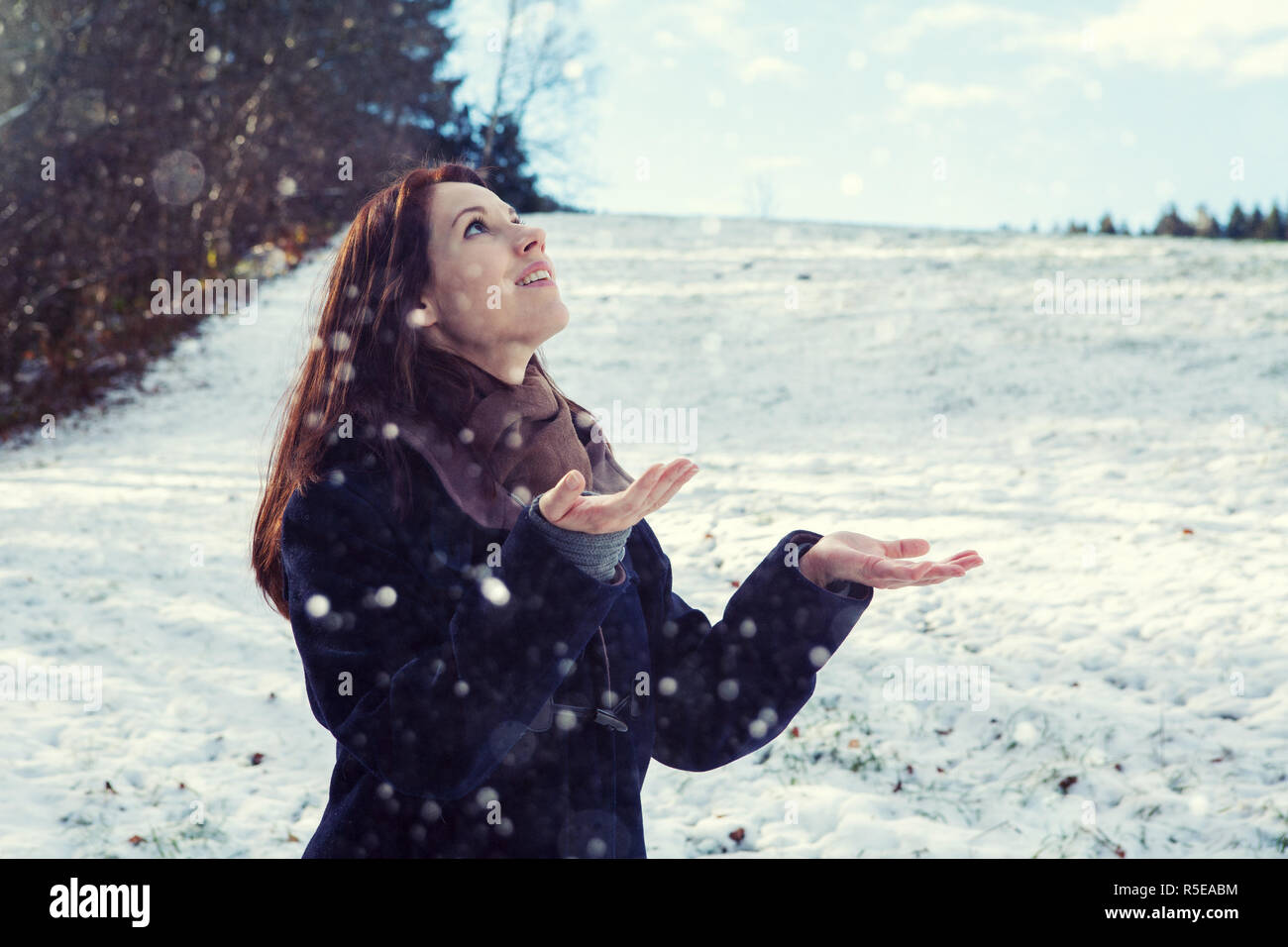 Bruna giovane donna in piedi all'aperto e godere la neve Foto Stock