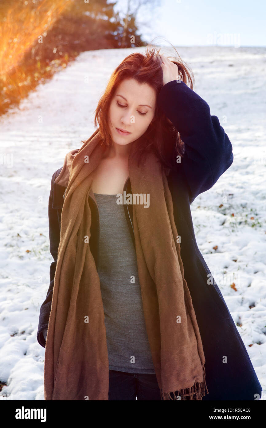 Ritratto di giovane donna bruna all'aperto in piedi nella neve Foto Stock
