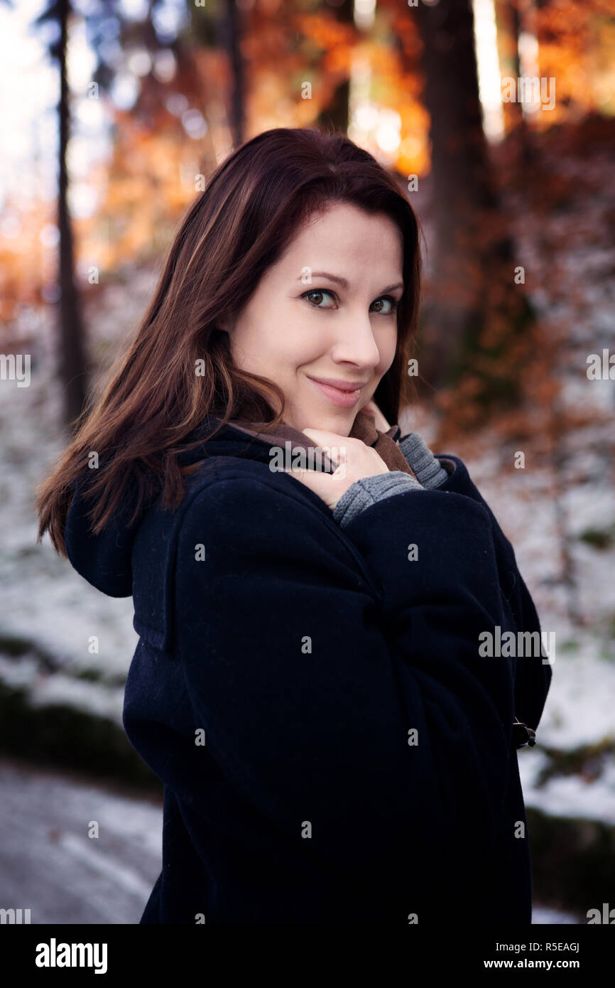 Ritratto di giovane donna bruna all'aperto in piedi nella neve Foto Stock