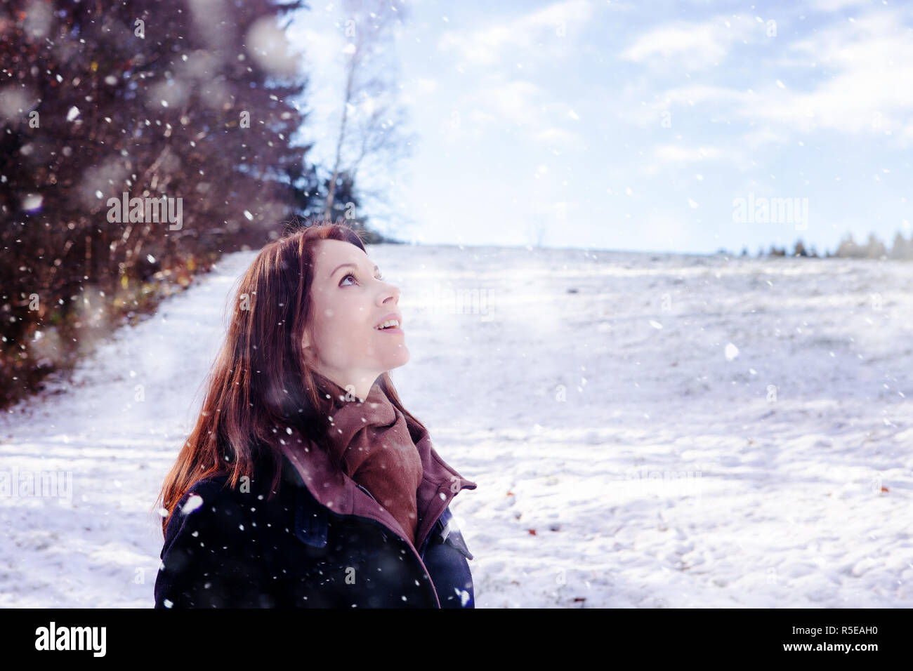 Bruna giovane donna in piedi all'aperto e godere la neve Foto Stock