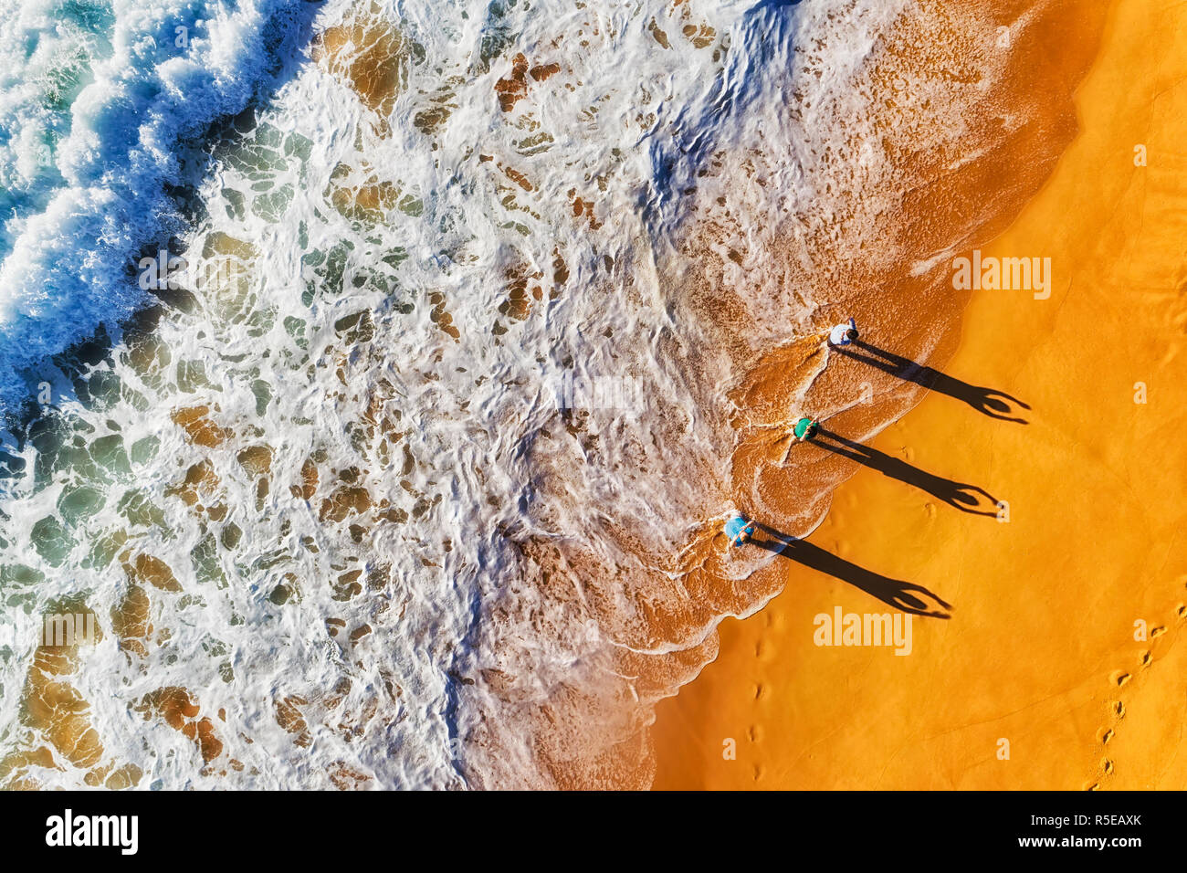 Gruppo di attivi sport sano persone che esercitano presso le onde che si infrangono sulle rive dell'oceano Pacifico largo sabbie di spiagge settentrionali in Australia, a Sydney, Foto Stock