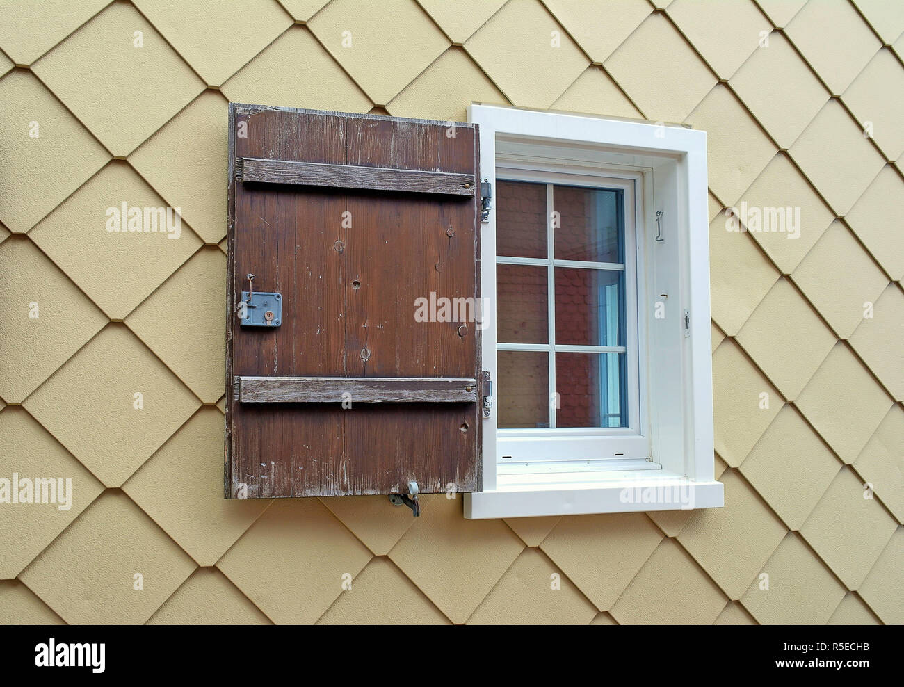 Finestra di casa con un unico in legno rustico otturatore Foto Stock