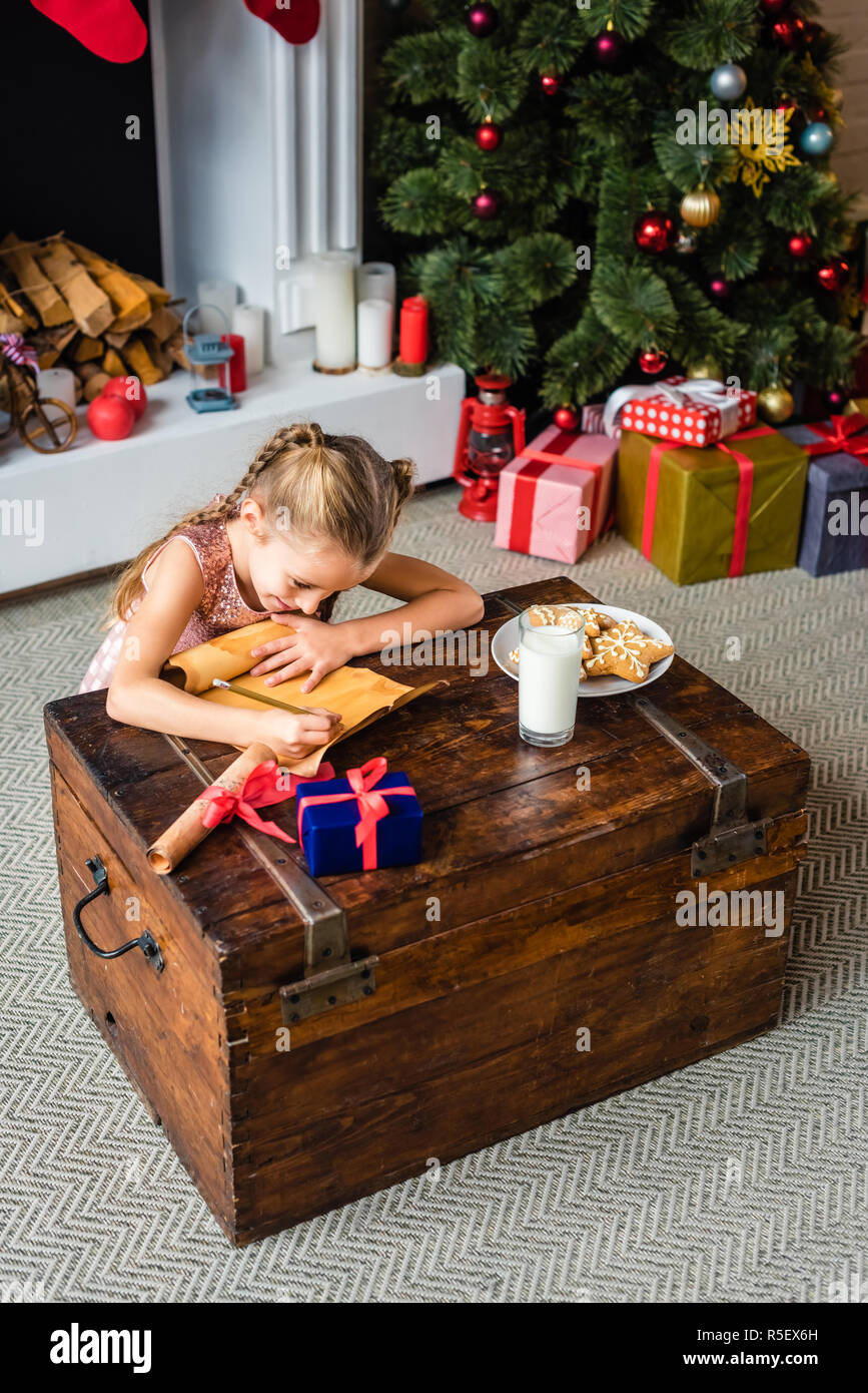 Elevato angolo di vista adorabili poco bambino wishlist di scrittura su pergamena del tempo di Natale Foto Stock