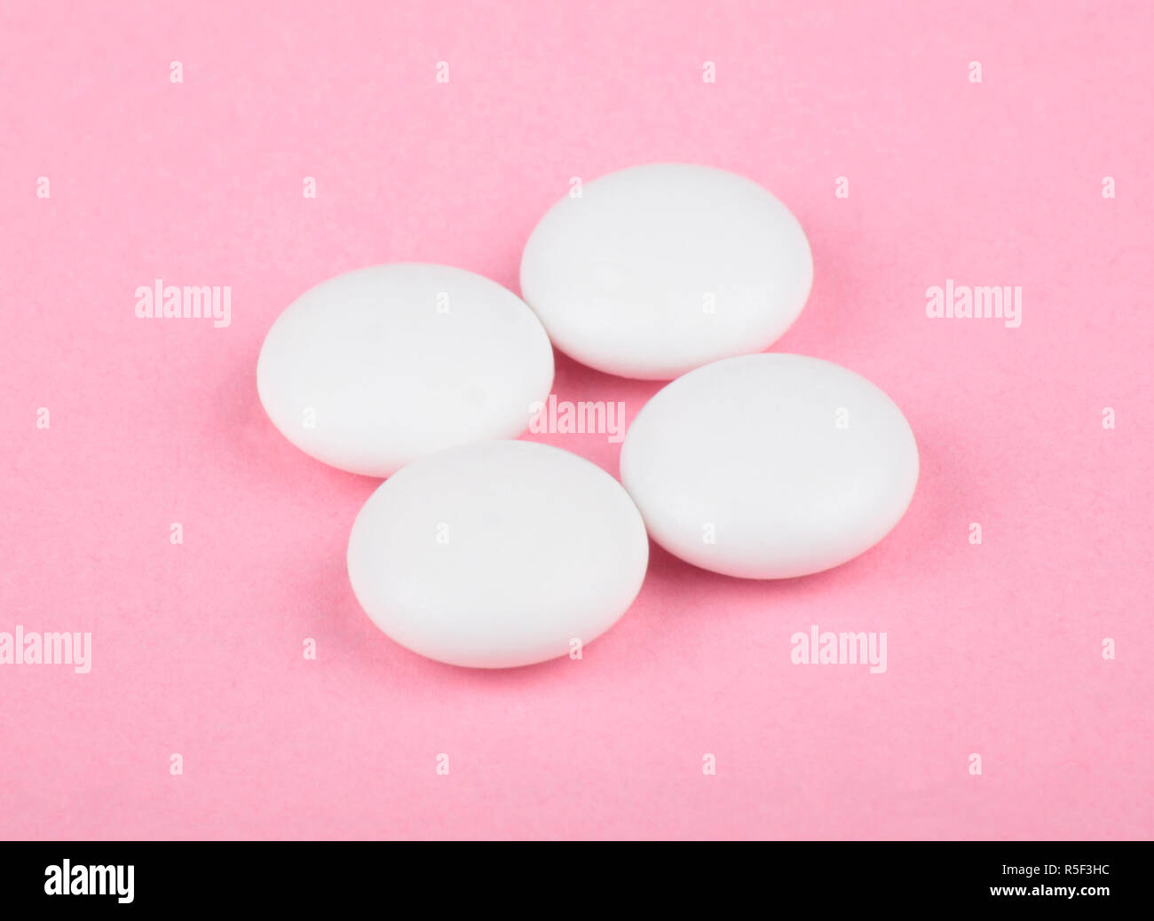 Pillola bianco su sfondo rosa Foto Stock