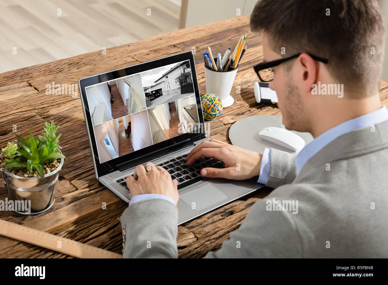 Imprenditore controllo video TVCC su Laptop Foto Stock