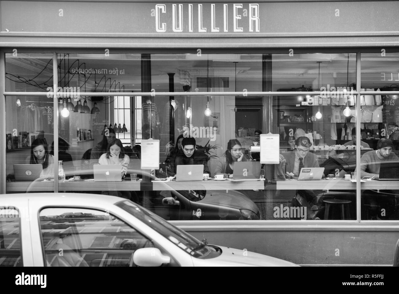 Persone che utilizzano il laptop nella finestra di una street cafe a Parigi, Francia Foto Stock