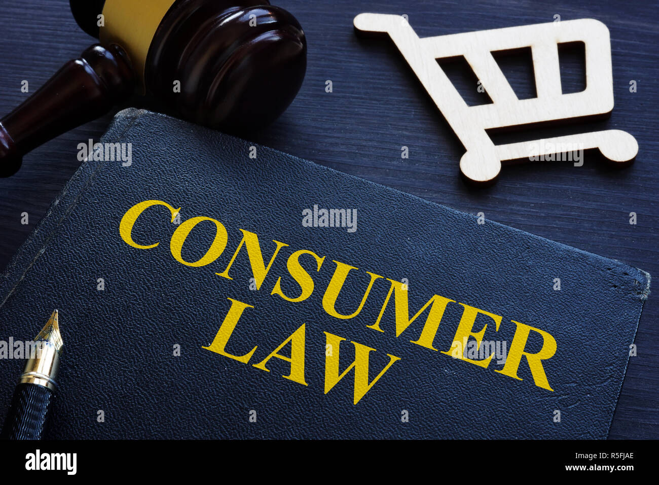 Diritto dei consumatori, martello e carrello su una scrivania. Foto Stock