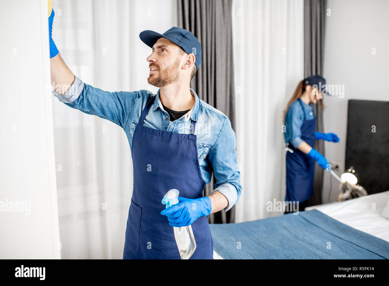 Fuoco selettivo del pulitore afroamericano nella tappezzeria uniforme di  pulizia del lettino a casa Foto stock - Alamy