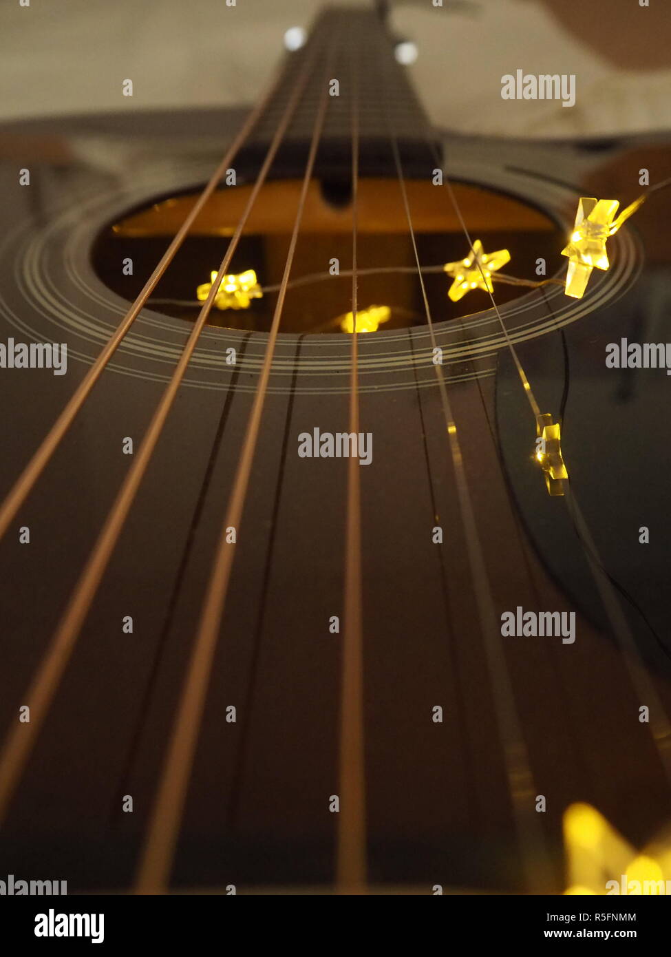 Star luce stringa appeso sulle corde di una chitarra acustica Foto Stock