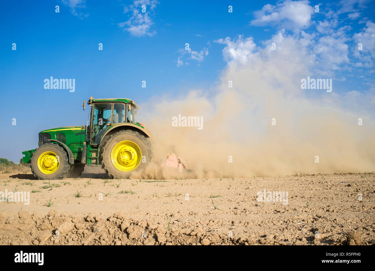 Badajoz, Spagna - 11 OTT 2017: trattore agricolo la preparazione di suolo polveroso colpiti dalla siccità. La siccità e il concetto di agricoltura Foto Stock