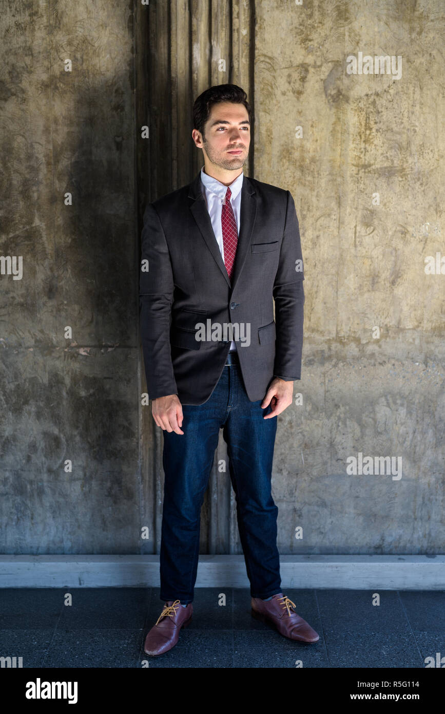 Ritratto di giovane imprenditore bello indossare tuta in città Foto Stock