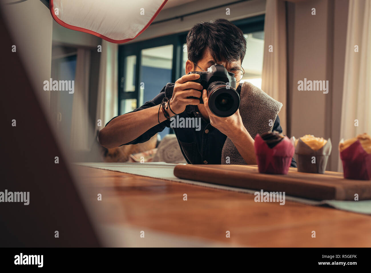Cibo fotografo utilizzando una fotocamera digitale per scattare una foto di dessert. Fotografo professionista durante il cibo sparare nel suo studio. Foto Stock