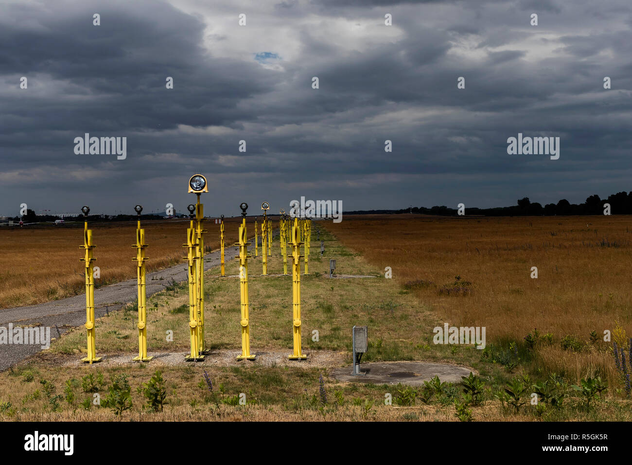 Aeroporto approccio sistema di illuminazione alla fine di una pista con le nuvole pesanti in background. Foto Stock