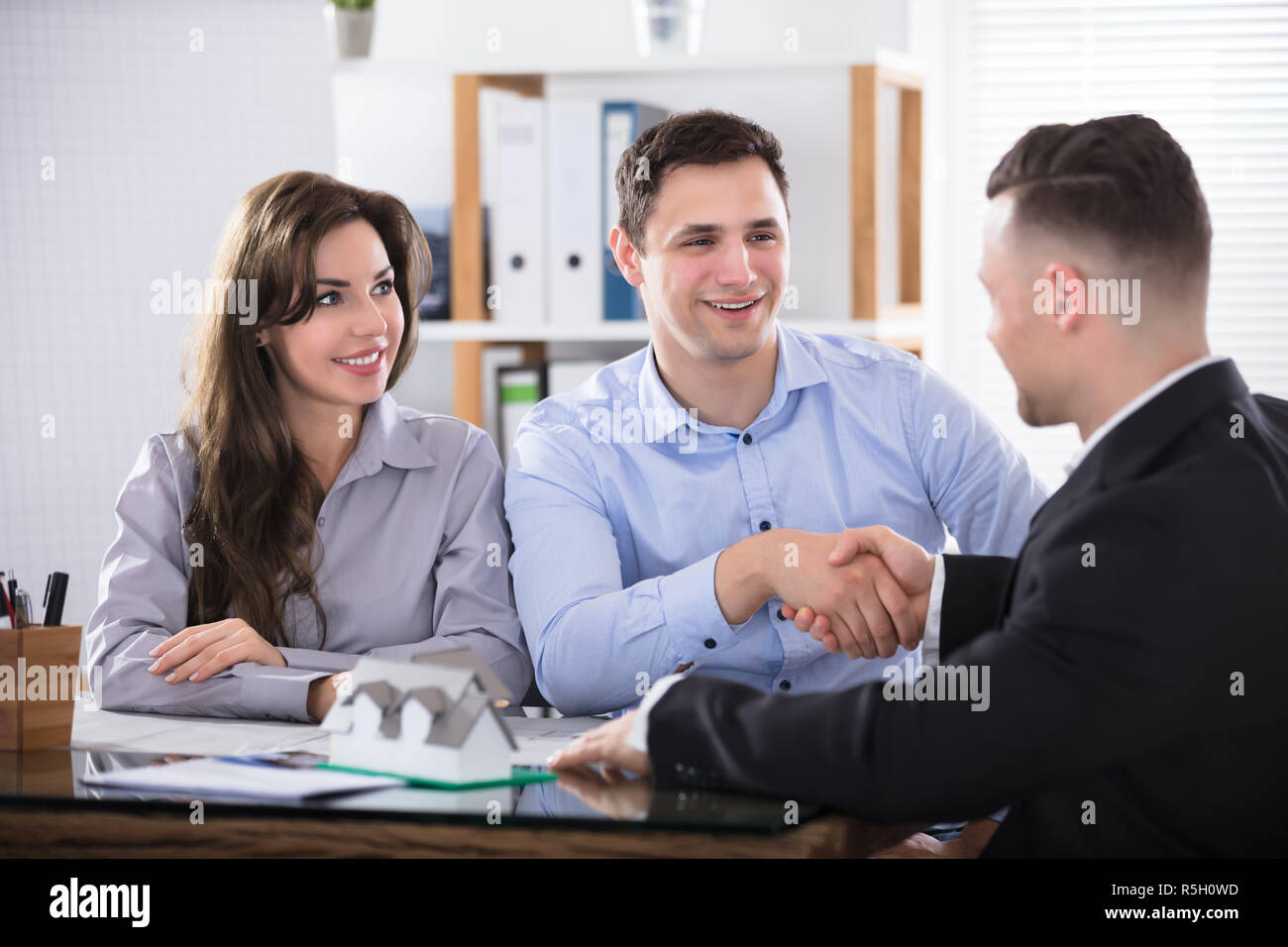 Giovane stringono le mani con Real Estate Advisor Foto Stock